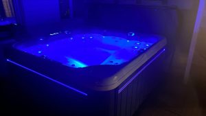 Jacuzzi éclairé en bleu la nuit.